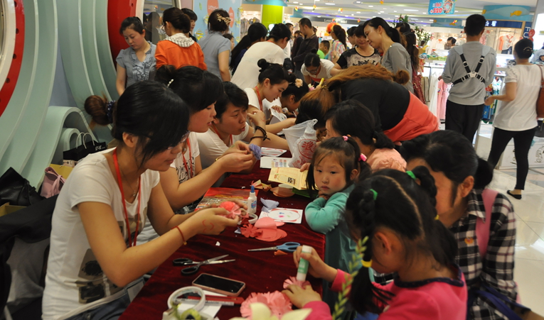 手工剪紙花活動現場工作人員一對一的耐心指導