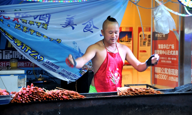 攤主載歌載舞烹制烤肉串